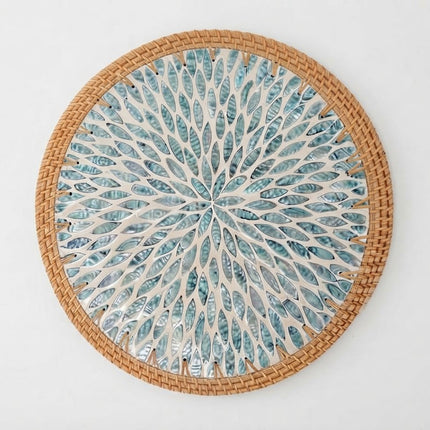 Turquoise mother of pearl rattan placemat featuring a beautiful radiant leaf and floral burst pattern in blue and aqua tones.
