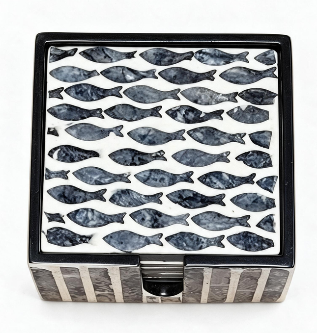 Handcrafted mother-of-pearl coasters with elegant navy fish pattern, styled with a refreshing citrus drink.