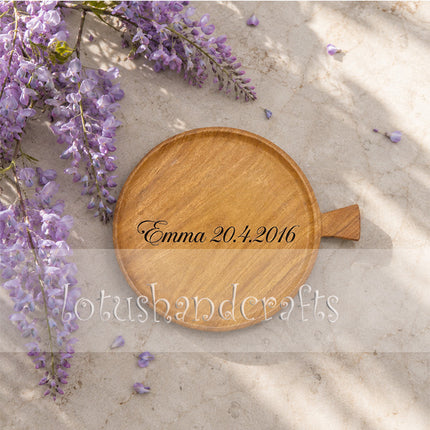 This small round ashwood serving tray with a handle offers custom name engraving upon request.