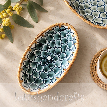 Overlapping floral motifs and fine petal outlines add depth, movement, and handcrafted character to the oval plate.