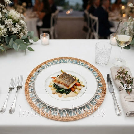 Handcrafted round rattan placemat with luminous turquoise floral and leaf motifs, adding coastal elegance to any dining table.