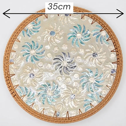 Close-up of delicate blue and green swirling floral motifs beautifully arranged across a luminous mother of pearl surface.