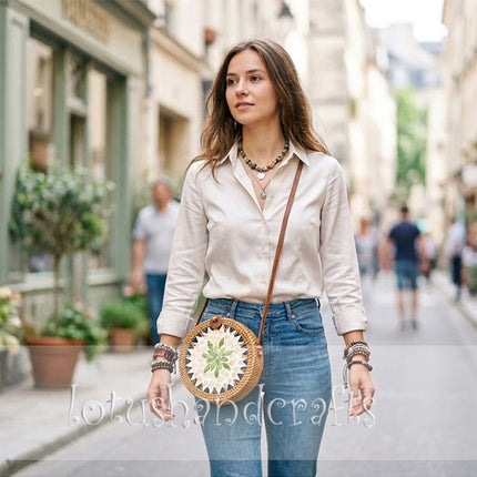 Discover a unique round rattan crossbody bag with mother of pearl leaf mosaic and leather strap.