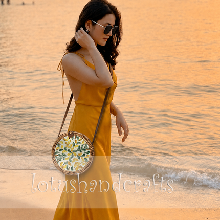 Captivating round rattan crossbody bag with green and yellow mother of pearl leaf inlay.