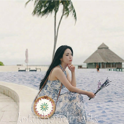 Unique green daisy round rattan crossbody bag with mother of pearl inlay and straw purse charm.
