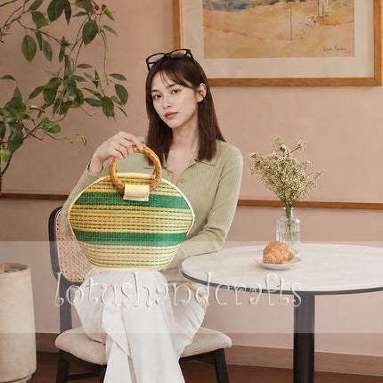 Handmade seagrass straw handbag with rattan handles in a cute half moon woven tote design.