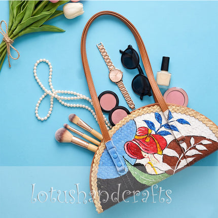 The woven grass half moon bag with a painted lady looks youthful and striking.