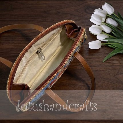 The unique woven grass half moon bag features a beautiful painted lady on its surface.