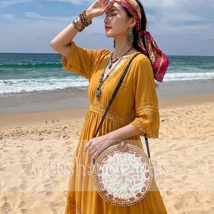 Round rattan crossbody bag with pink petal mother of pearl inlay that attracts every glance.