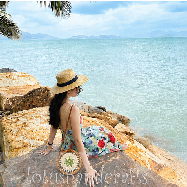 Unique round rattan crossbody bag with a handcrafted green leaf and pearl mosaic inlay.