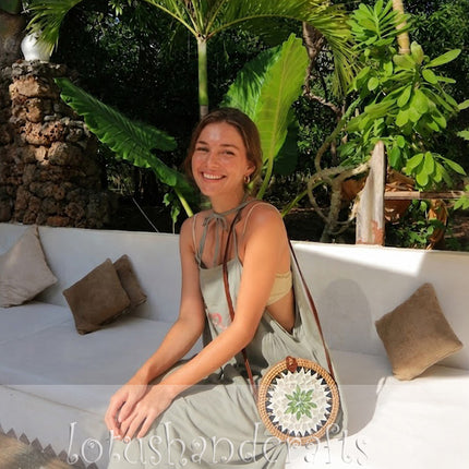 Cute round rattan crossbody bag with a charming green leaf and pearl mosaic inlay.
