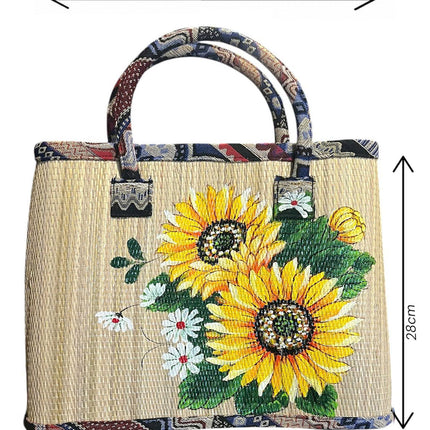 Handwoven seagrass tote bag with vibrant sunflower painting.