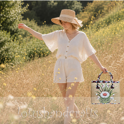 Handmade woven seagrass tote bag with a hand-painted white daisy garden.