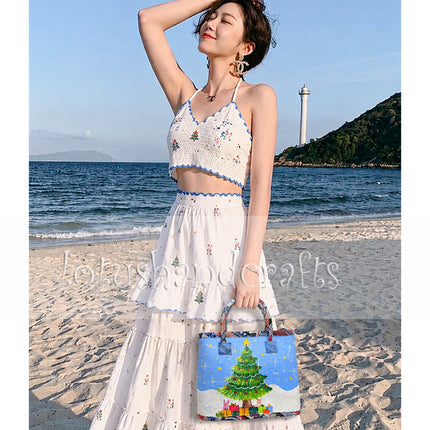 Handmade woven seagrass tote bag with painted Christmas tree design and charming appeal.
