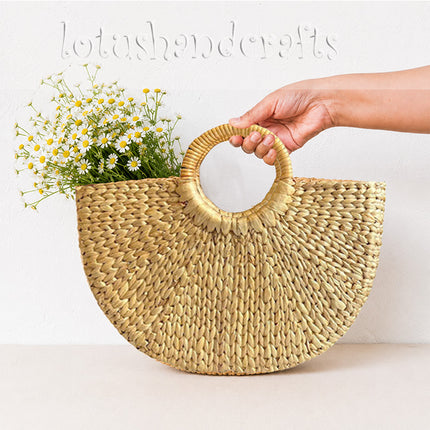 Handwoven half moon seagrass tote bag with round handles for a chic look.