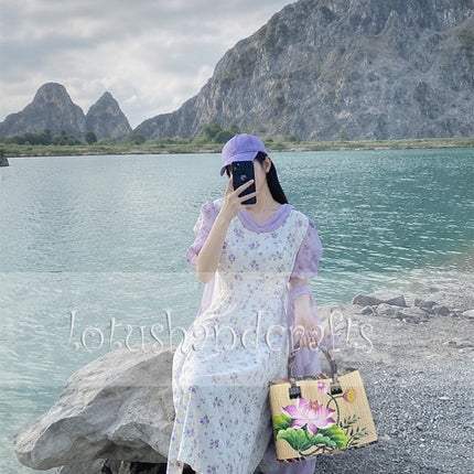 Handmade woven seagrass tote bag with a hand-painted lotus blossom for a youthful and elegant look.