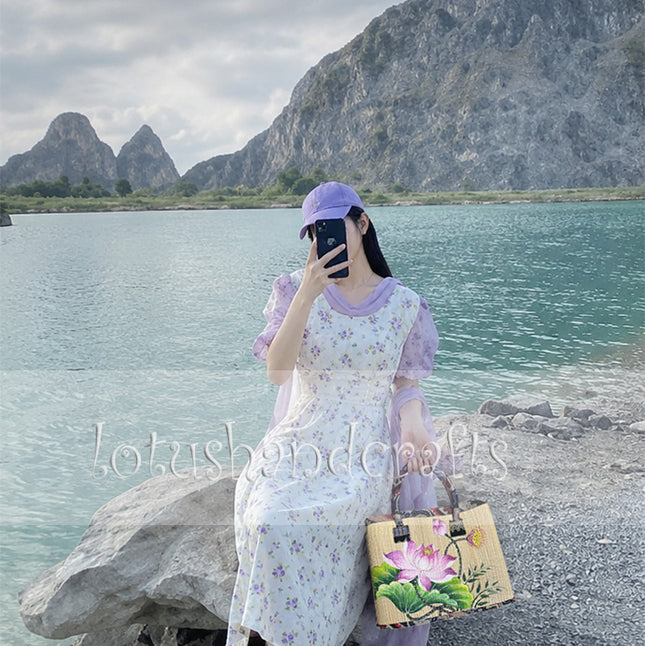 Handmade woven seagrass tote bag with a hand-painted lotus blossom for a youthful and elegant look.