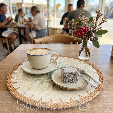 A 35cm round Mother of Pearl placemat with an eye-catching green leaf bloom design, perfect for elegant dining arrangements.