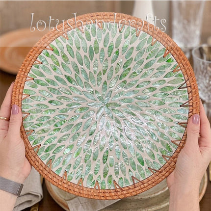 Round rattan placemat with shimmering green mother of pearl leaf inlay.