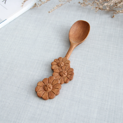 A beautiful handcrafted wooden spoon with a three flower handle design brings elegance and charm to any home kitchen space.