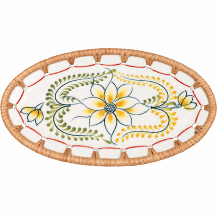 Hand-painted oval ceramic tray featuring a graceful golden yellow flower surrounded by flowing green vines and delicate botanical leaves, framed with natural woven rattan.