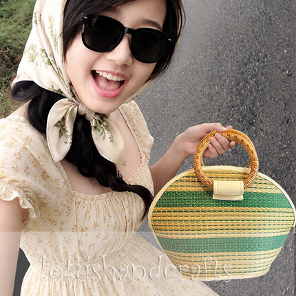Handmade seagrass straw handbag with a rattan handle in a cute half moon woven tote design.