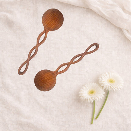 Hand carved twisted long handle wooden spoon made from natural wood for durable kitchen use.