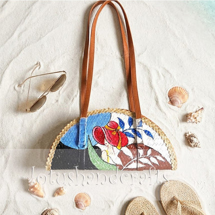 This woven grass half moon bag with a painted lady truly attracts every passing glance.