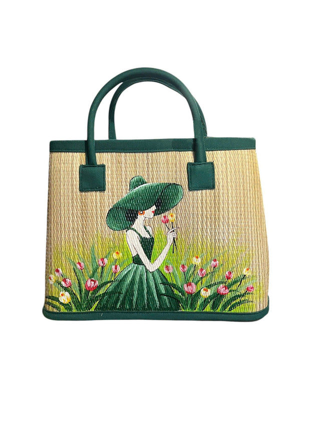 Handmade woven seagrass tote bag featuring elegant green lady artwork.