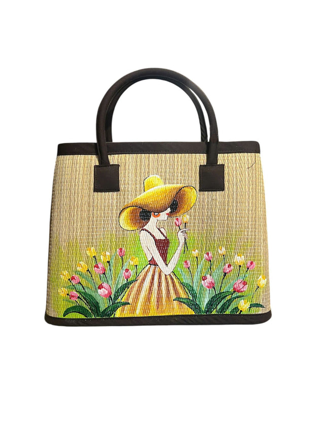 Handwoven seagrass tote bag with a charming hand-painted girl in a tulip garden.