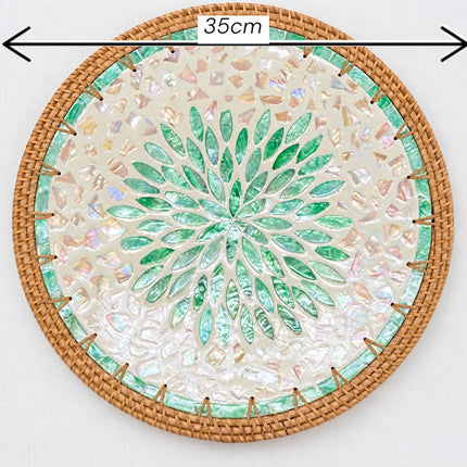 35cm round handcrafted placemat showcasing an eye-catching green botanical motif, shimmering shell inlay, and natural rattan border.