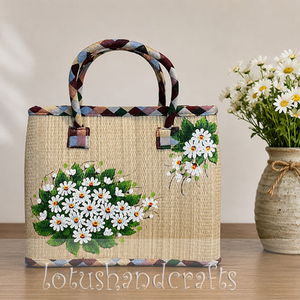 Luxury handwoven seagrass tote bag with painted daisy design.