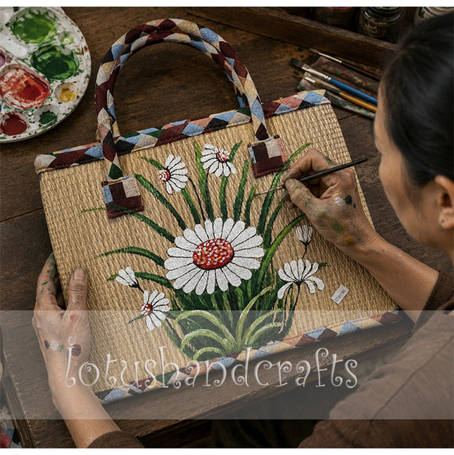 Handmade woven seagrass tote bag with a hand-painted white daisy garden design.