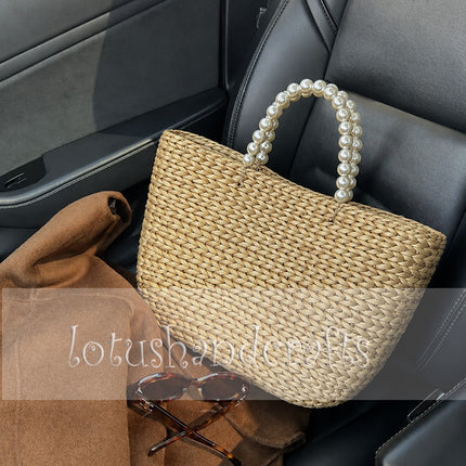 Handwoven water hyacinth tote bag with pearl handles for stylish women.