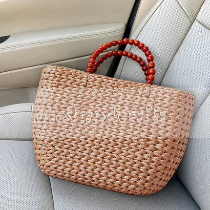 Eco friendly handwoven water hyacinth tote bag with wooden bead handles.