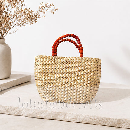 Handwoven water hyacinth tote bag with wooden bead handles in boho style.
