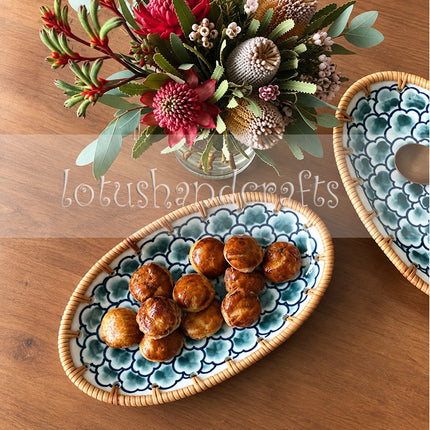 The combination of detailed floral ceramic artwork and woven rattan reflects the distinctive beauty of Vietnamese artisan craftsmanship.