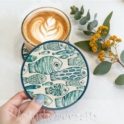 Showcase beautifully detailed fish with flowing stripes, dotted accents, and expressive eyes on this artistic ceramic drink coaster.