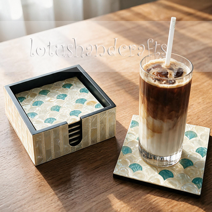An aqua fish scale coaster set arranged with white ceramic tableware, natural wood, and soft linen accents to create a relaxed, ocean-inspired home décor setting.
