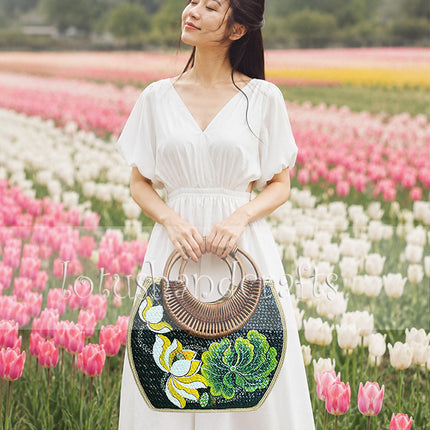 Handwoven rattan bag with seashell accents and hand painted lotus blossom.