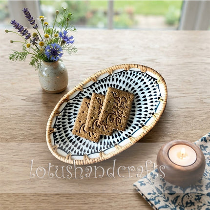 Intricate black and gray sunburst design creating a striking concentric pattern on the oval tray.