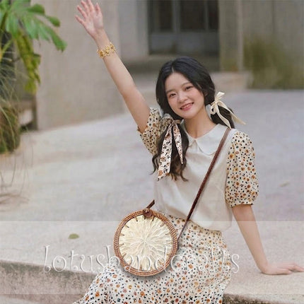 Young handmade round rattan crossbody bag with elegant mother of pearl flower inlay.