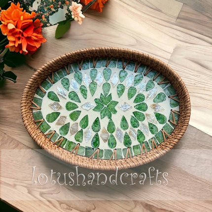 This handwoven oval rattan tray featuring a luxury green leaf mother of pearl mosaic inlay is truly elegant.