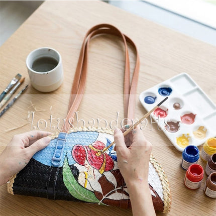 The highly artistic Woven Grass Half-Moon Bag Painted Lady beautifully elevates your everyday summer style.