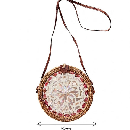 Round rattan crossbody bag featuring pink petal mother of pearl inlay with elegant size.