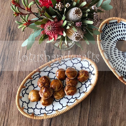 Handcrafted ceramic tray showcasing intricate floral artistry and natural woven rattan craftsmanship.