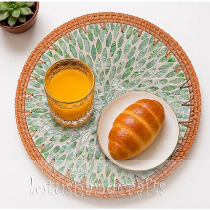 Round rattan placemat with shimmering green mother of pearl leaf inlay.
