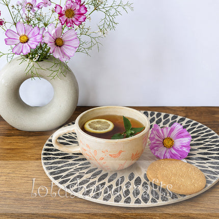 Handcrafted black and white mother of pearl placemat with a radiant leaf mosaic design.