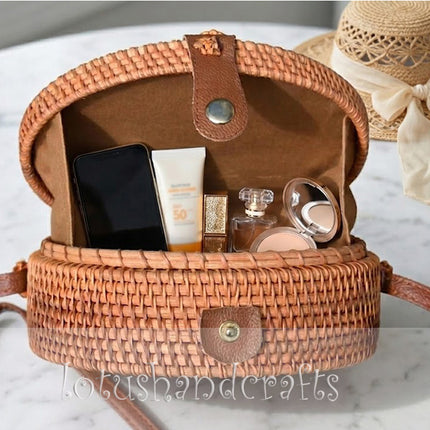 Elegant handmade round rattan crossbody bag featuring a delicate mother of pearl flower inlay.