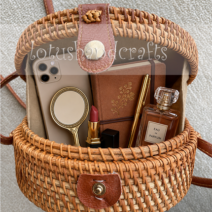 Elegant round rattan crossbody bag with green and yellow mother of pearl leaf inlay.